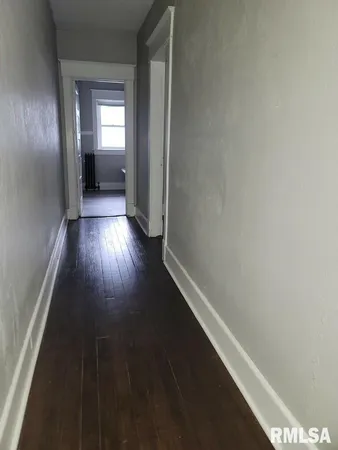 a view of hallway with wooden floor