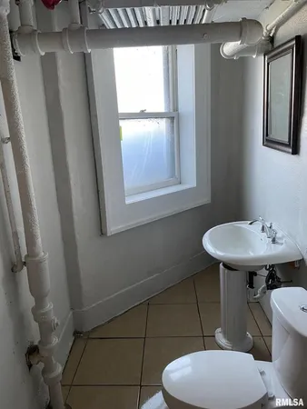 a bathroom with a toilet a sink and a mirror