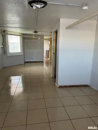 a view of a livingroom with an empty space and a window
