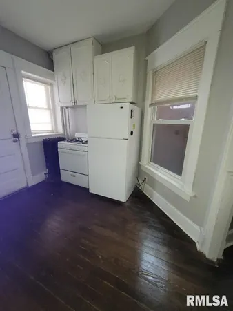 a living room with hard wood floors and white walls