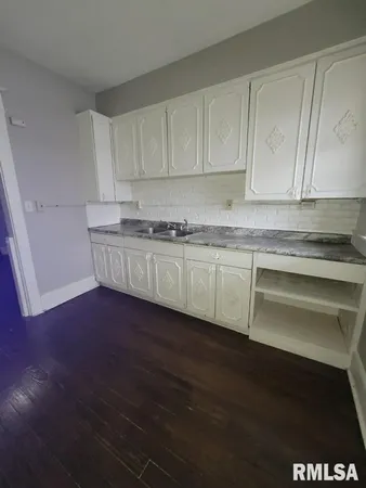 a kitchen with granite countertop a sink and cabinets