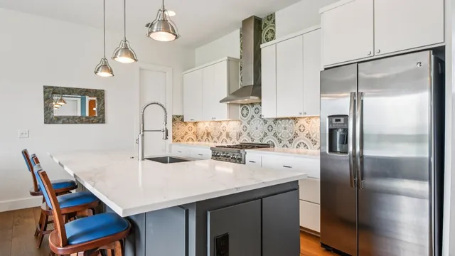 a kitchen with stainless steel appliances granite countertop a sink a stove and a refrigerator