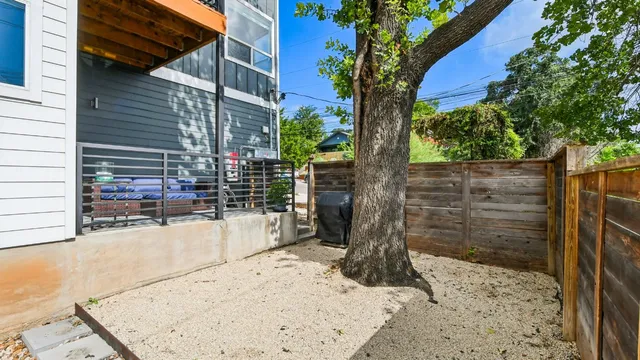 a view of a backyard space with wooden fence
