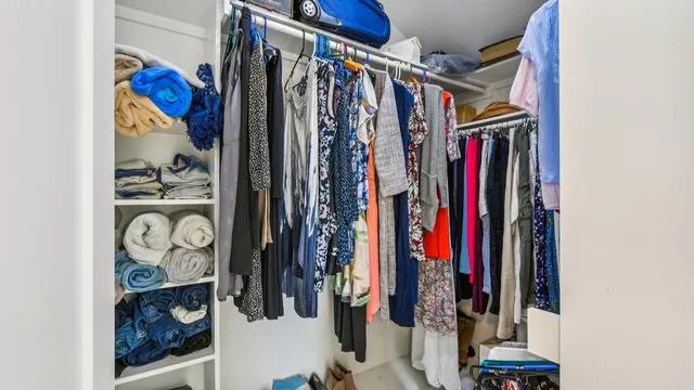 a view of walk in closet with clothes and shoes