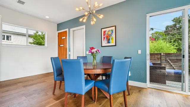 a dining room with furniture potted plants and wooden floor