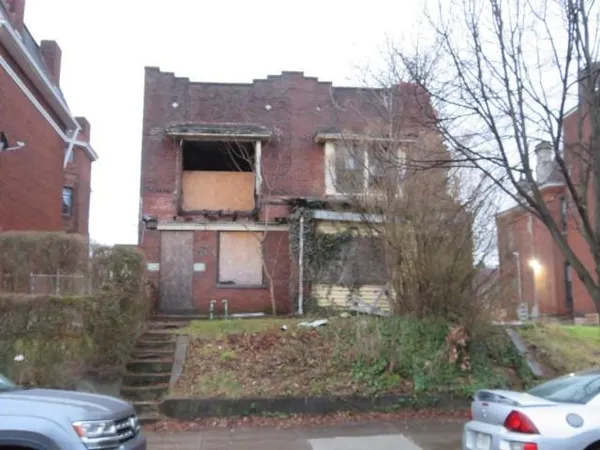 a view of a brick house next to a yard