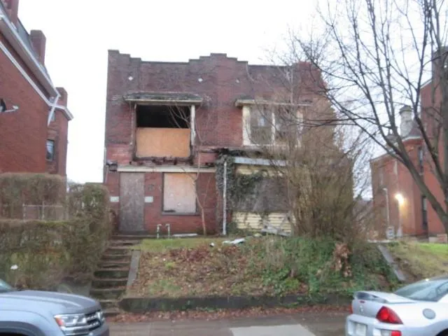 a view of a brick house next to a yard