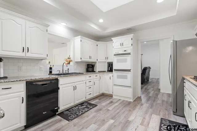 a kitchen with white cabinets and stainless steel appliances