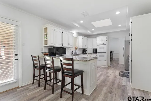 a kitchen with a dining table chairs and refrigerator