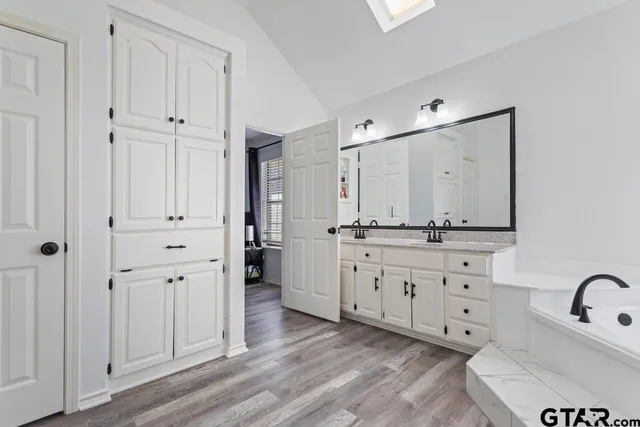 a bathroom with white cabinets and sink