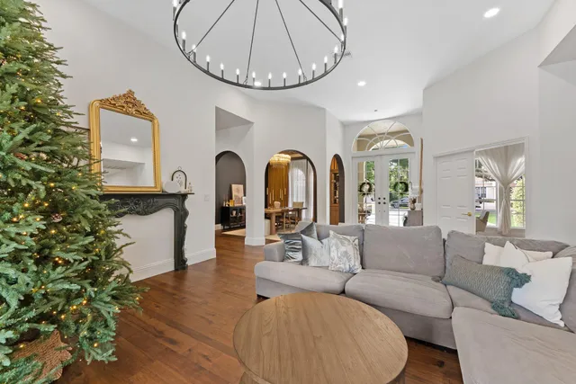 a living room with furniture a chandelier and a window