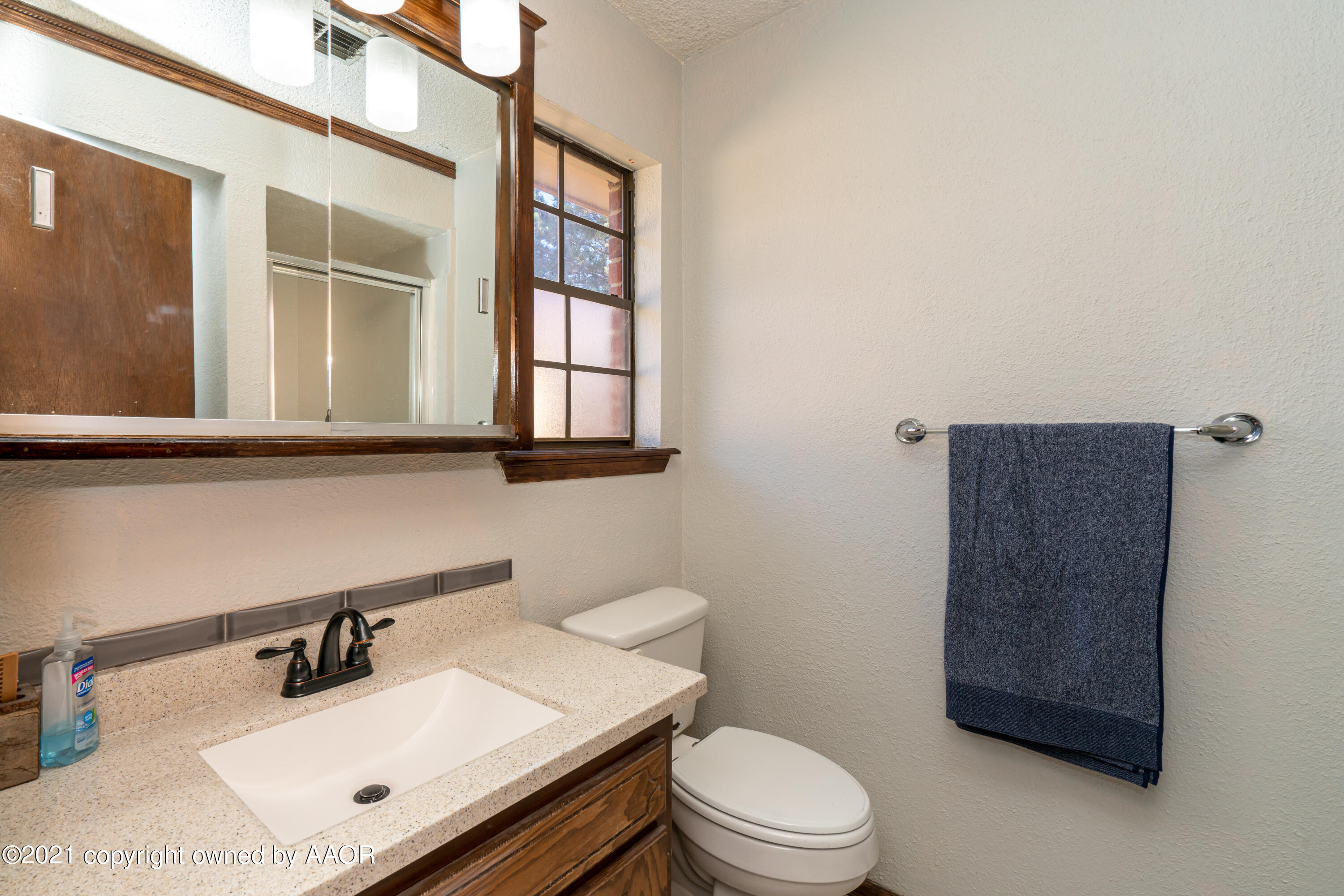 5811 Hardwick Drive Amarillo, TX 79109 - Photo 17 of 24 a bathroom with a sink vanity mirror and toilet
