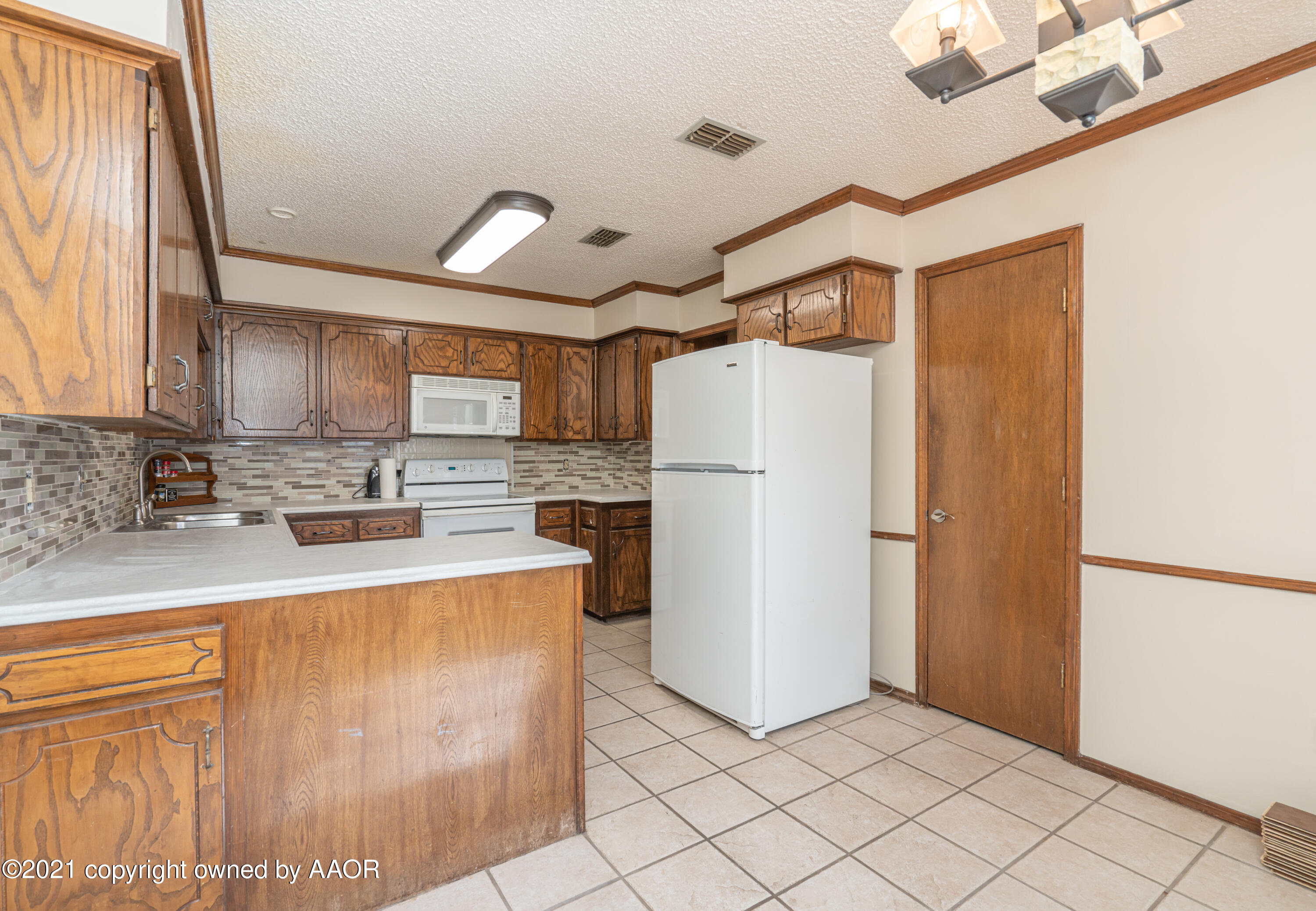 5811 Hardwick Drive Amarillo, TX 79109 - Photo 7 of 24 a kitchen with refrigerator cabinets and a counter top space