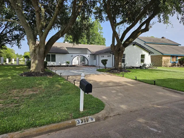 a front view of a house with a yard and an tree