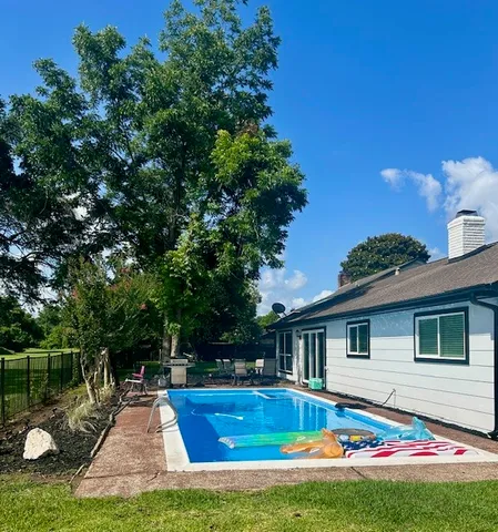 a front view of house with yard and swimming pool