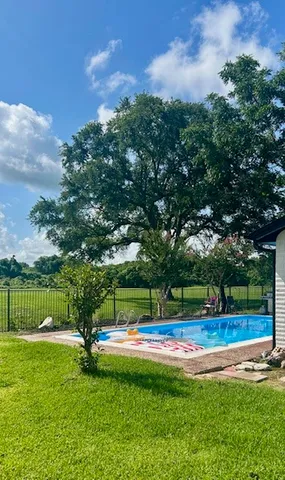 a view of yard with swimming pool and green space