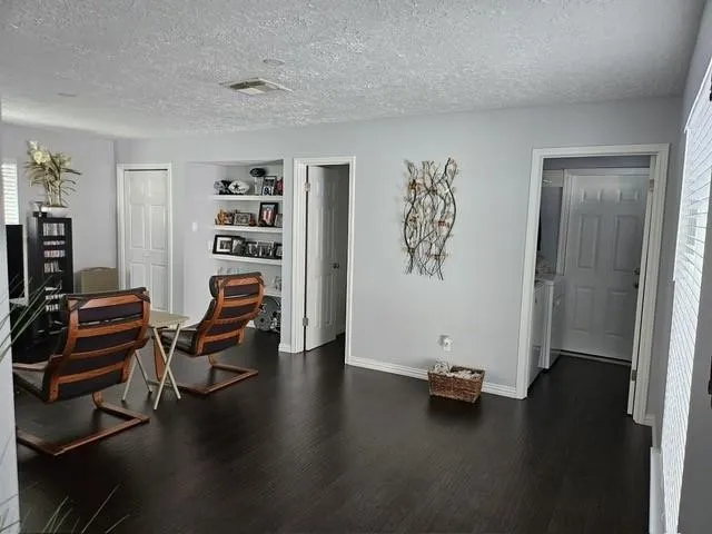 a view of a workspace with furniture and wooden floor