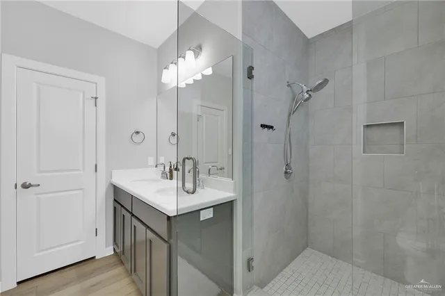 a bathroom with a sink shower and a mirror
