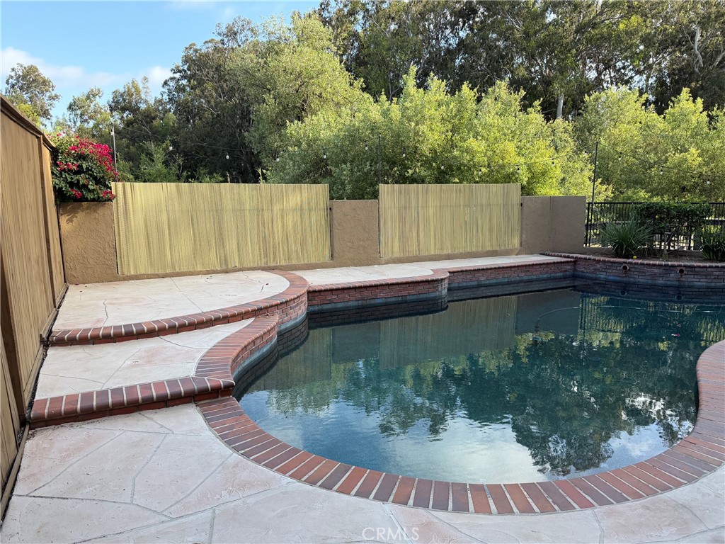 24422 Vía Del Rio Lake Forest, CA 92630 - Photo 39 of 41 a view of a swimming pool with a yard and trees in the background