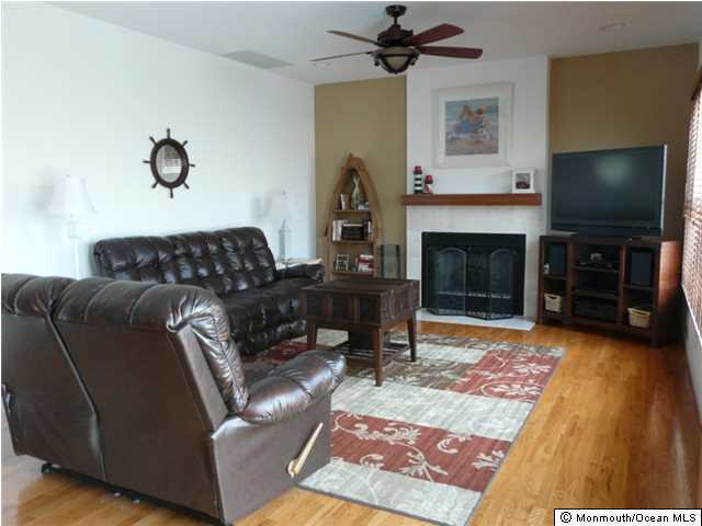 85 Club House Road Brick, NJ 08723 - Photo 6 of 20 a living room with furniture a flat screen tv and a fireplace