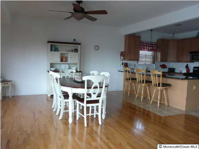 85 Club House Road Brick, NJ 08723 - Photo 8 of 20 a dining room with furniture wooden floor a rug and a kitchen