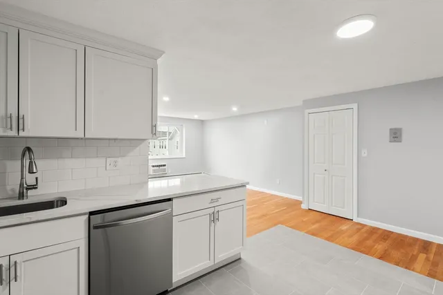 a kitchen with stainless steel appliances granite countertop a sink and dishwasher with white countertops