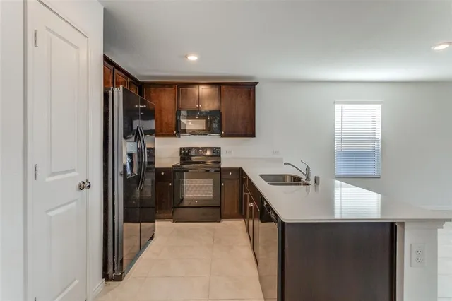 a kitchen with stainless steel appliances granite countertop a refrigerator a sink and a stove
