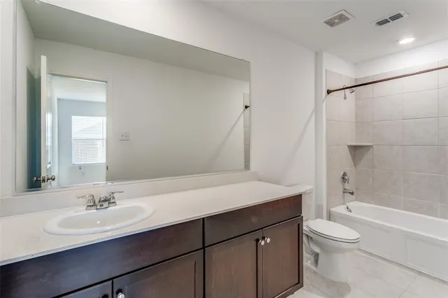 a bathroom with a granite countertop sink toilet a large mirror and shower