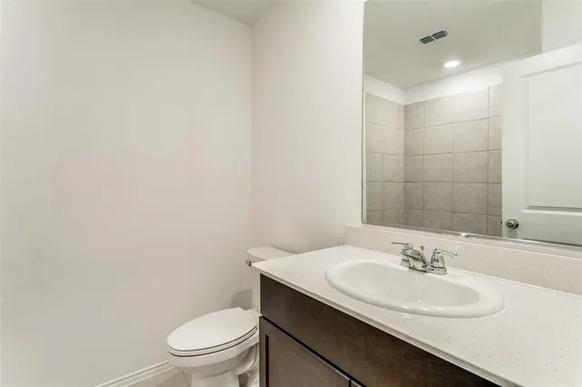a bathroom with a sink toilet and a mirror