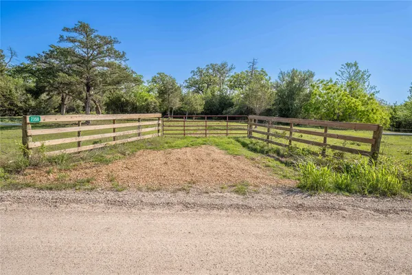 a view of a yard with wooden fence