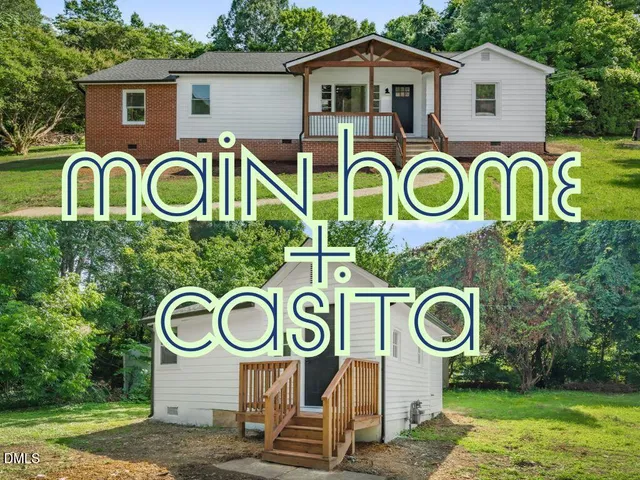 a view of a brick house with a small yard and a large tree