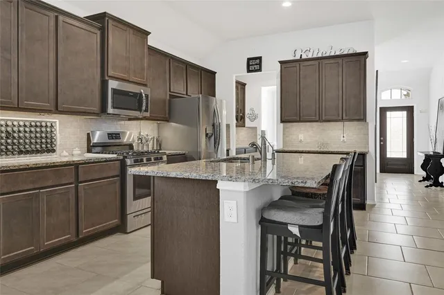 a kitchen with stainless steel appliances granite countertop a sink stove and cabinets
