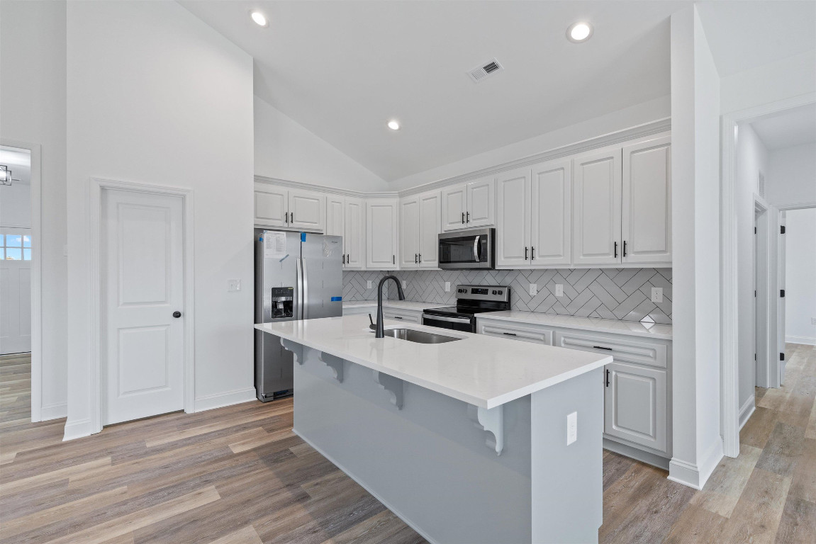 4000 Origin Drive Bailey, NC 27807 - Photo 11 of 47 a kitchen with white cabinets and stainless steel appliances