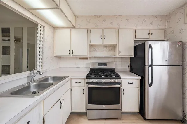 a kitchen with stainless steel appliances a stove a sink and a refrigerator