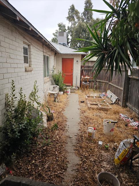 114 North J Street Madera, CA 93637 - Photo 13 of 20 a backyard of a house with table and chairs under an umbrella