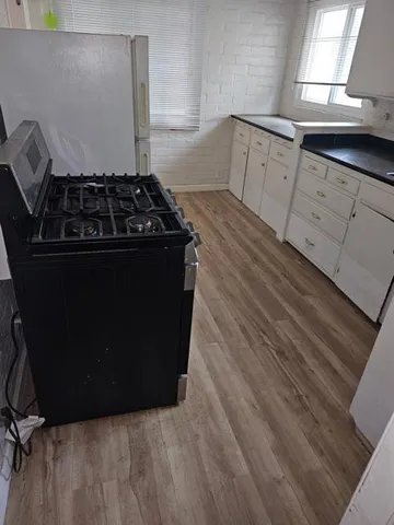 a kitchen with granite countertop a stove and a refrigerator