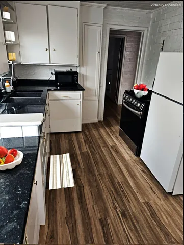 a kitchen with wooden floor and a stove top oven