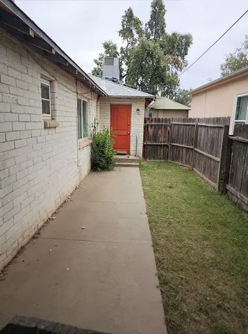 a backyard of a house with plants and brick wall
