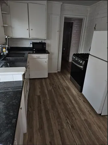a kitchen with a sink and wooden floor