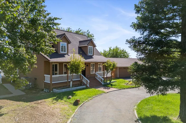 front view of house with a yard and potted plants