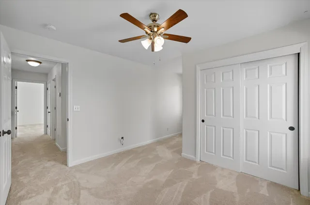 a view of a room with wooden floor and ceiling fan