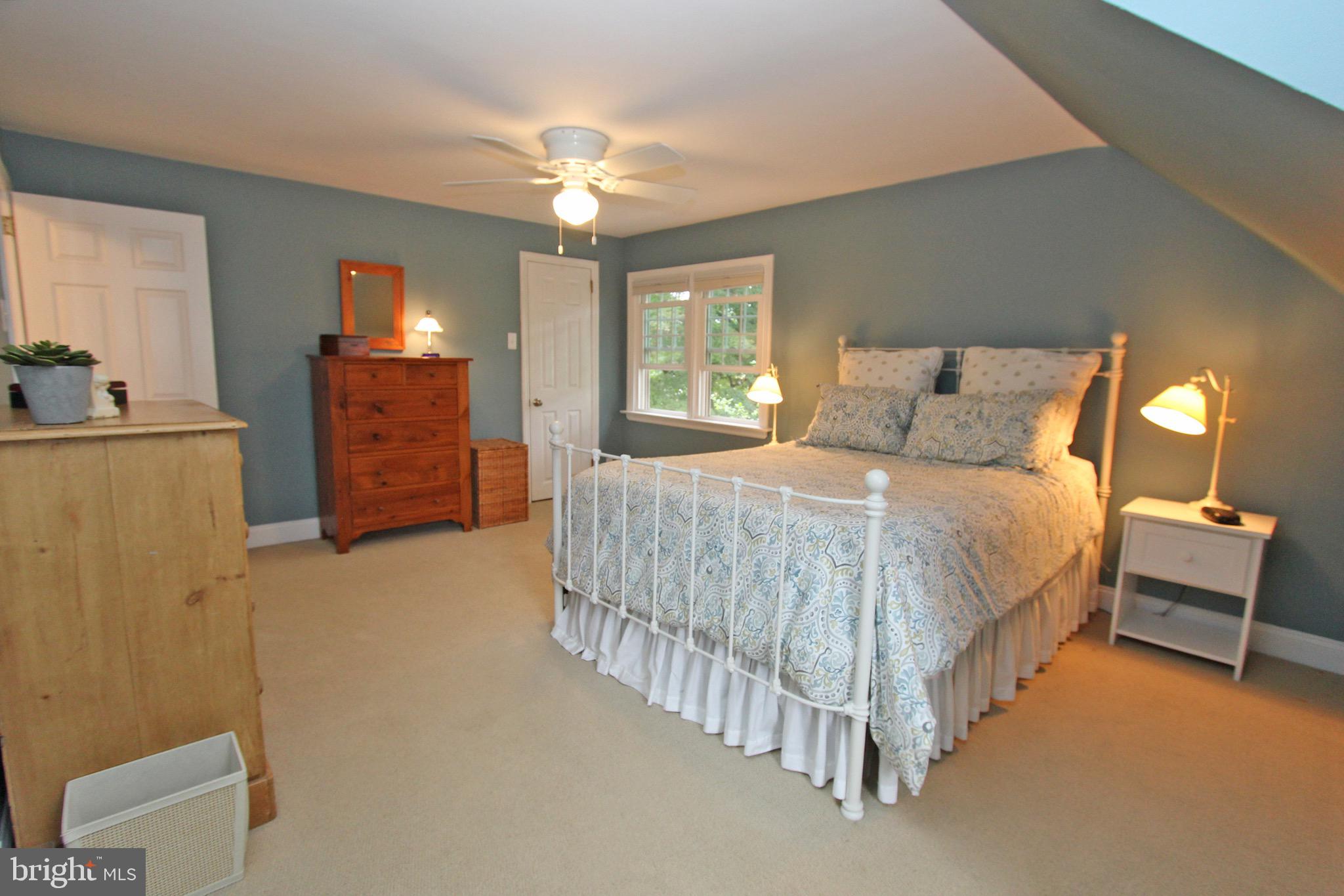 951 Conestoga Road Berwyn, PA 19312 - Photo 24 of 41 a spacious bedroom with a bed and a chandelier
