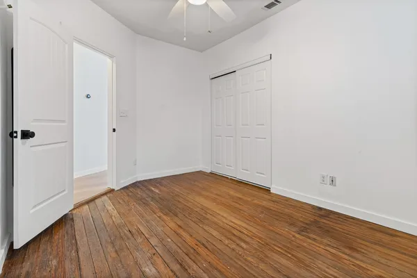 a view of an empty room with wooden floor