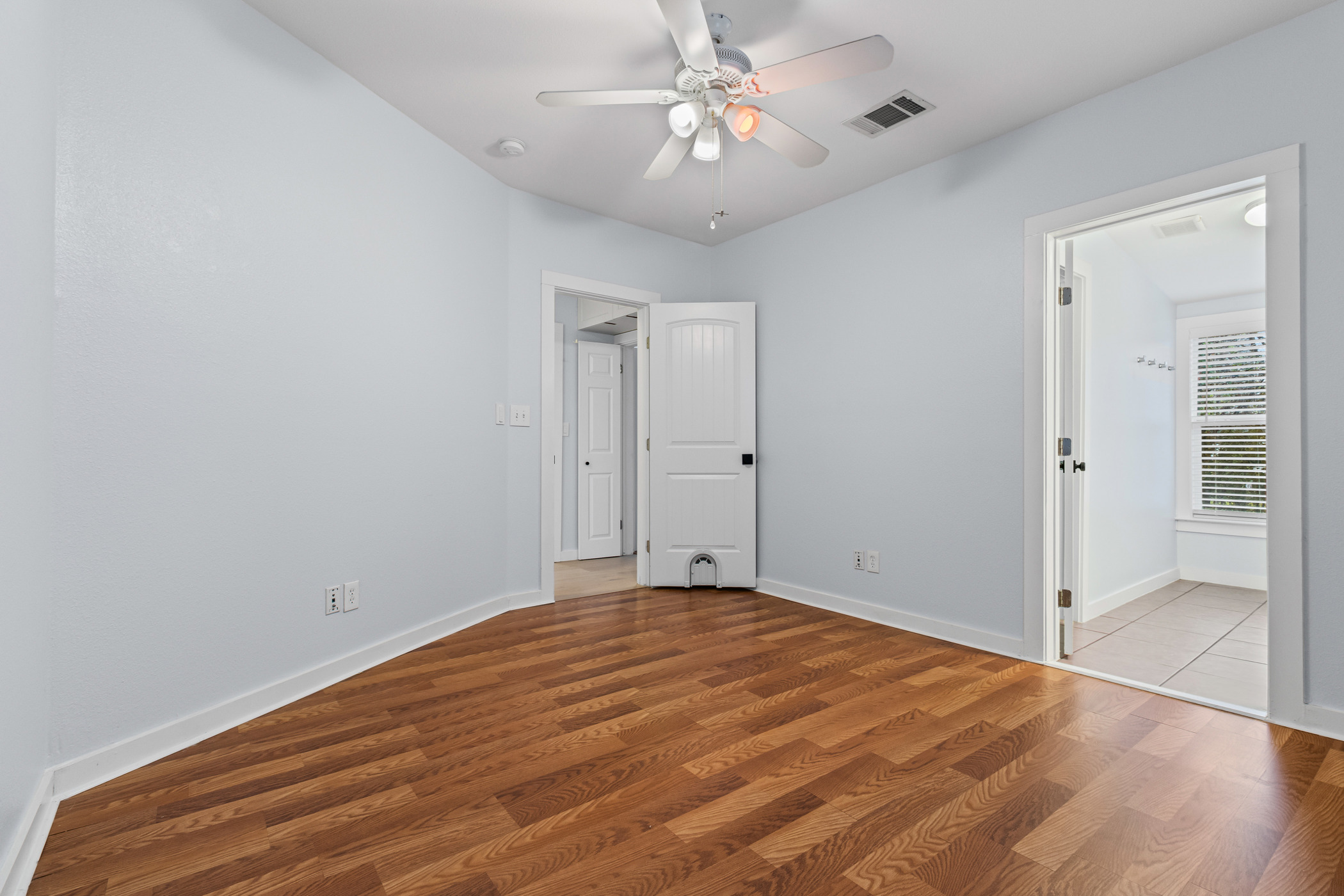 84 Waller Street Austin, TX 78702 - Photo 14 of 22 Unfurnished bedroom with wood finished floors and a ceiling fan