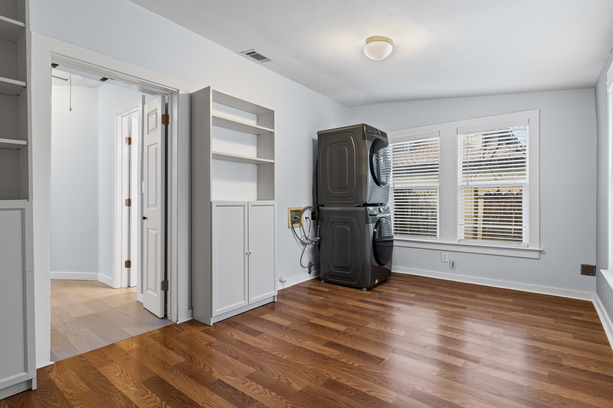 84 Waller Street Austin, TX 78702 - Photo 18 of 22 Unfurnished bedroom with dark wood-type flooring and stacked washer / dryer