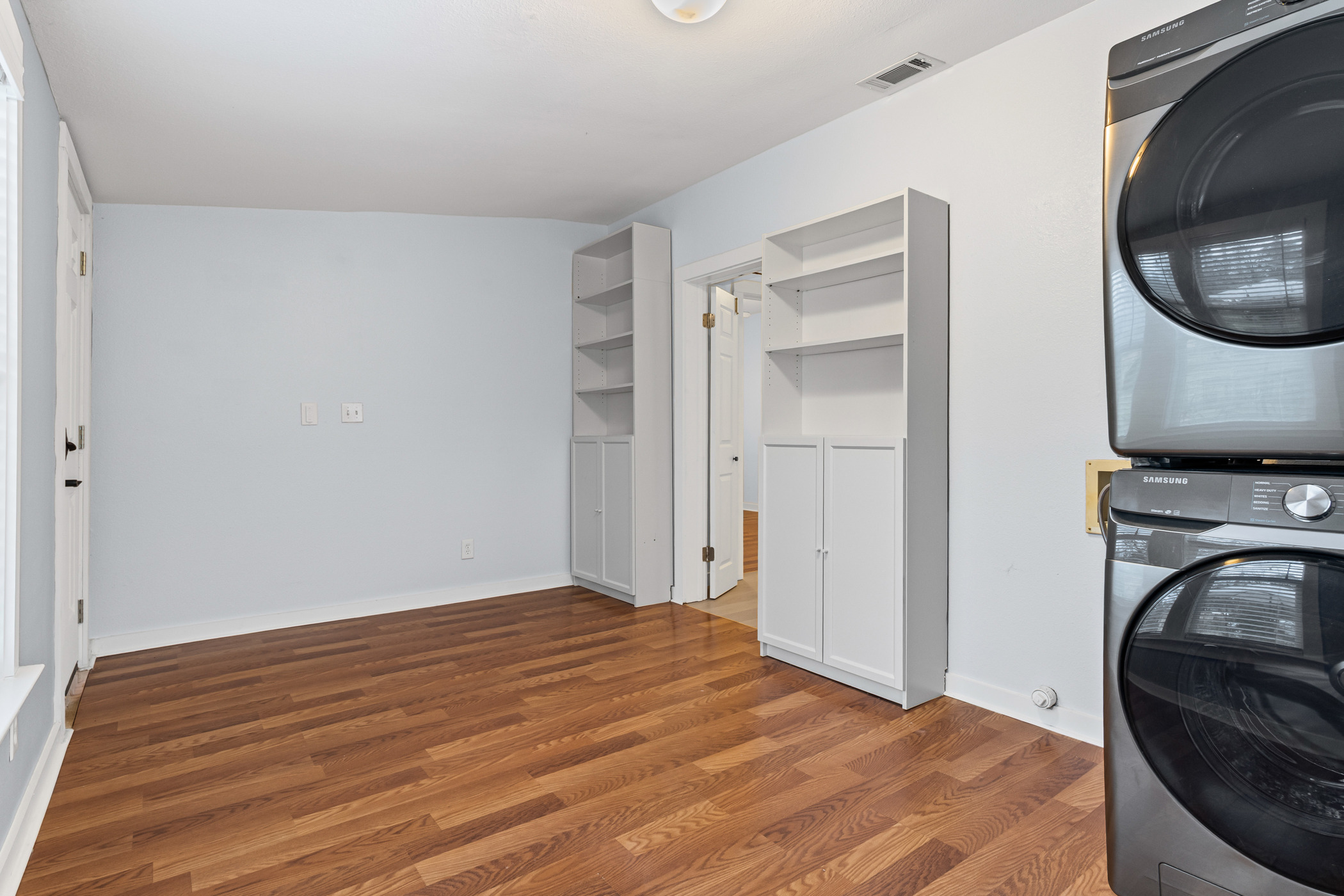 84 Waller Street Austin, TX 78702 - Photo 19 of 22 Laundry room featuring wood finished floors and stacked washer / drying machine