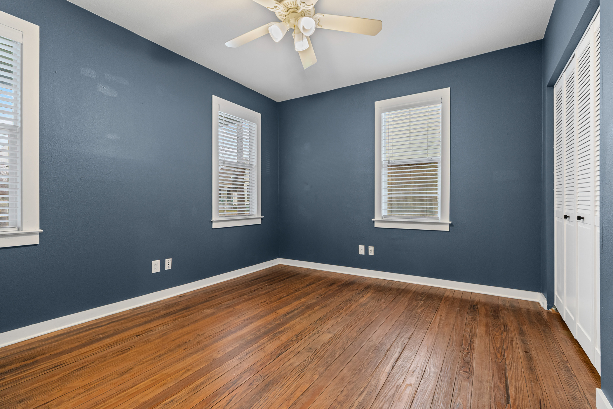 84 Waller Street Austin, TX 78702 - Photo 8 of 22 Unfurnished bedroom with dark wood-style floors, a closet, and a ceiling fan