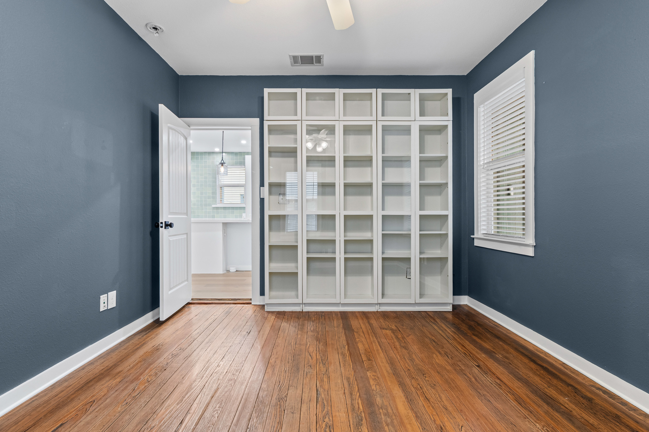 84 Waller Street Austin, TX 78702 - Photo 9 of 22 Unfurnished bedroom with dark wood finished floors, multiple windows, ceiling fan, and a closet