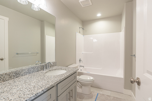 2257 South 1090 West, Unit 74 Nibley, UT 84321 - Photo 13 of 40 Bathroom featuring a speckled vanity countertop, undermount sink, built-in bathtub with shower, light gray cabinetry, and tile flooring