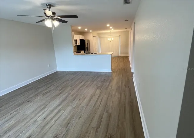 wooden floor in an empty room with a kitchen